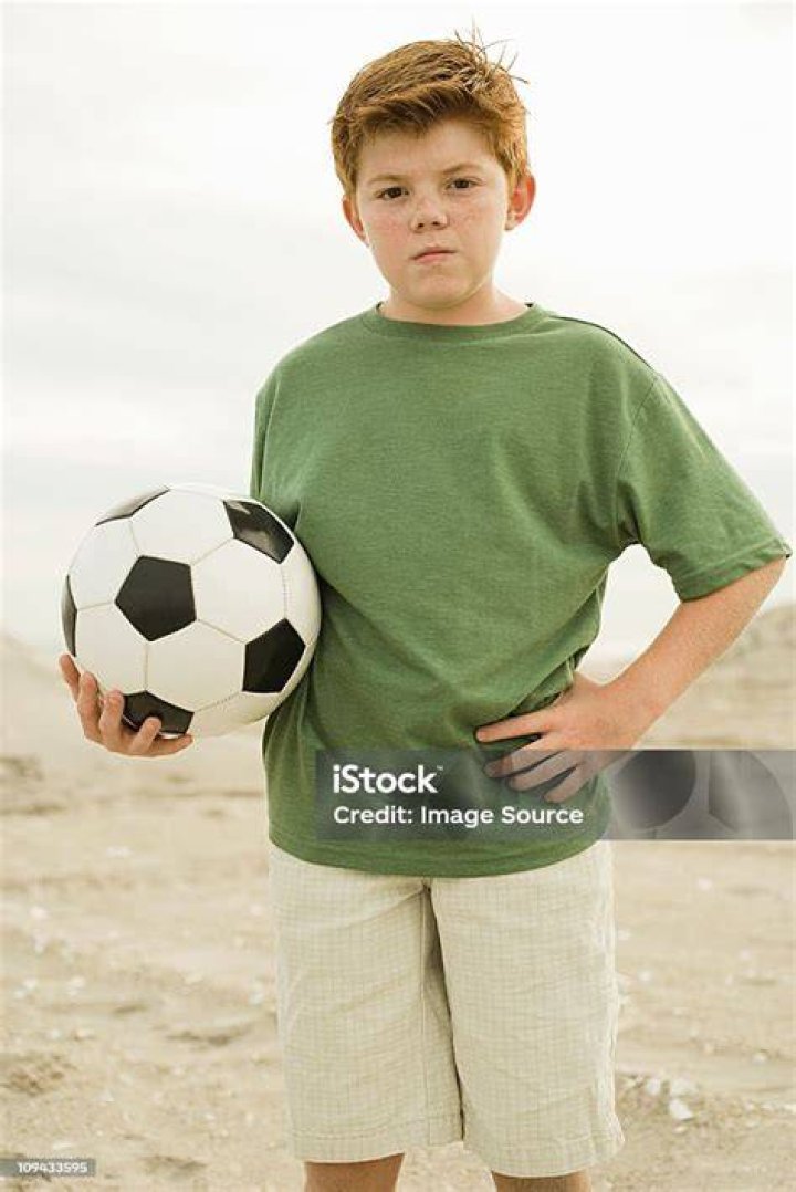 a boy holding a football ball