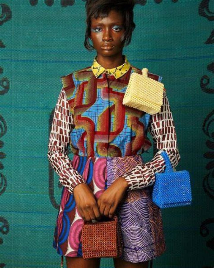 a model carrying a beaded white clutch on the simone rocha runway