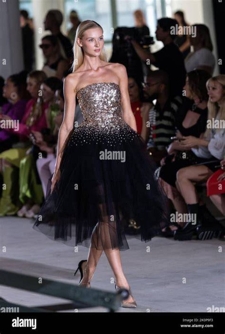 a model walks at paolina russo wearing a matching knit set and sneakers