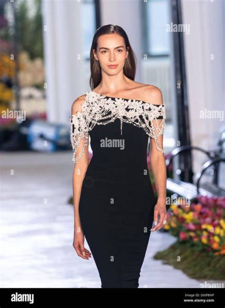 a model walks at the karoline vitto show wearing a side cutout dress adorned with charms