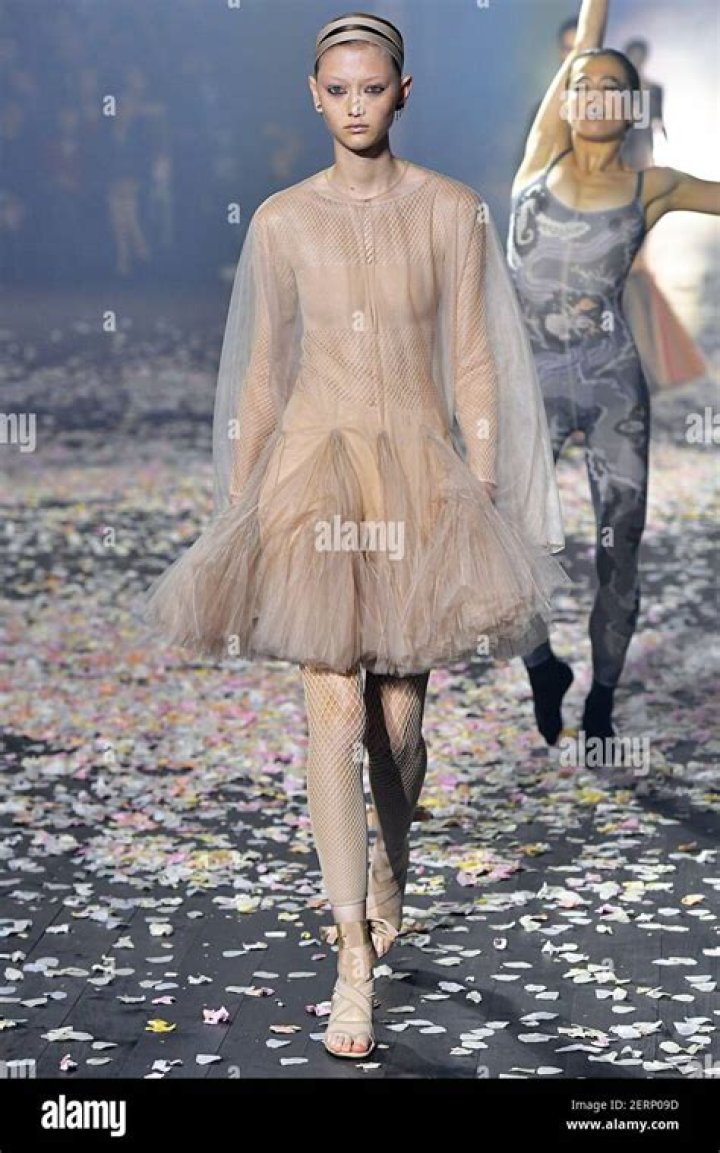 a model walks the grace ling runway in a black blazer and black column skirt