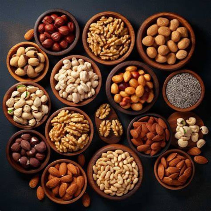 a variety of nuts and seeds arranged on a wooden table