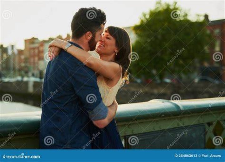 affectionate young couple in love lying on bed at home, talking