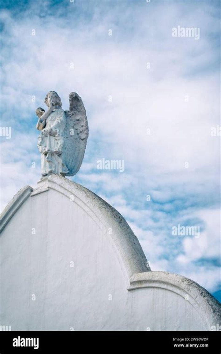 An angel on a white cloud against a clear blue sky with copy space