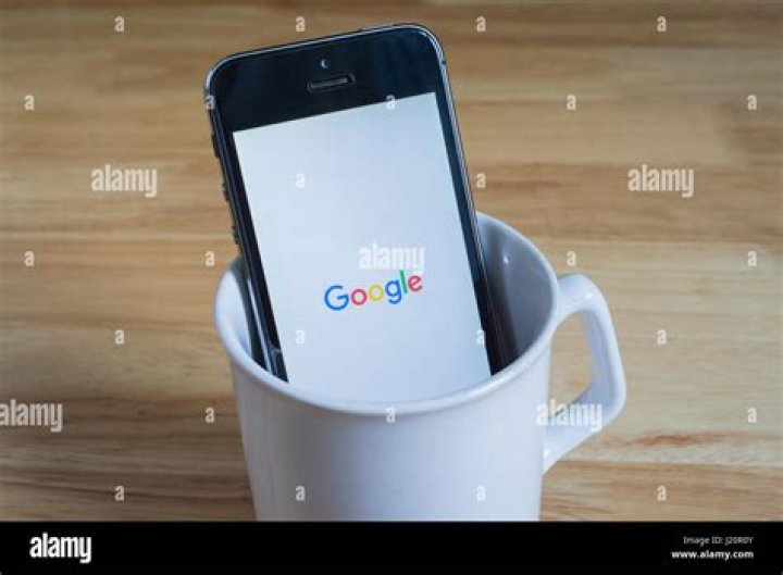 Apple iPhone5s in a mug showing its screen with Snapchat logo