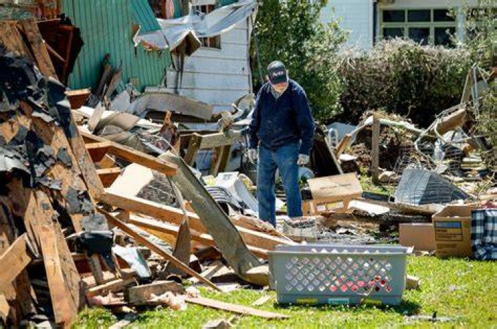 Bob Lambert Sr. digs through debris after a powerful tornado tore through the area the night before, killing his grandson. Photo / AP