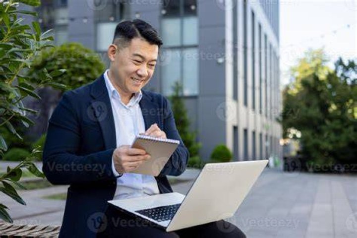 Cheerful people taking notes outside