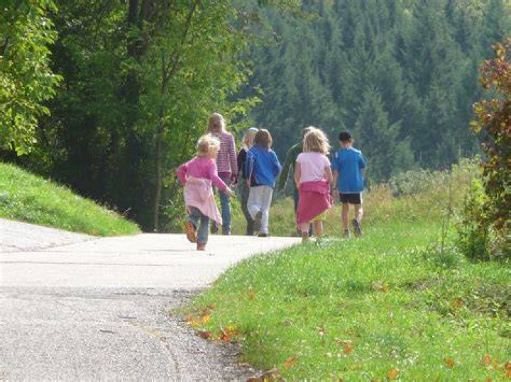 Children walking near the field during daytime