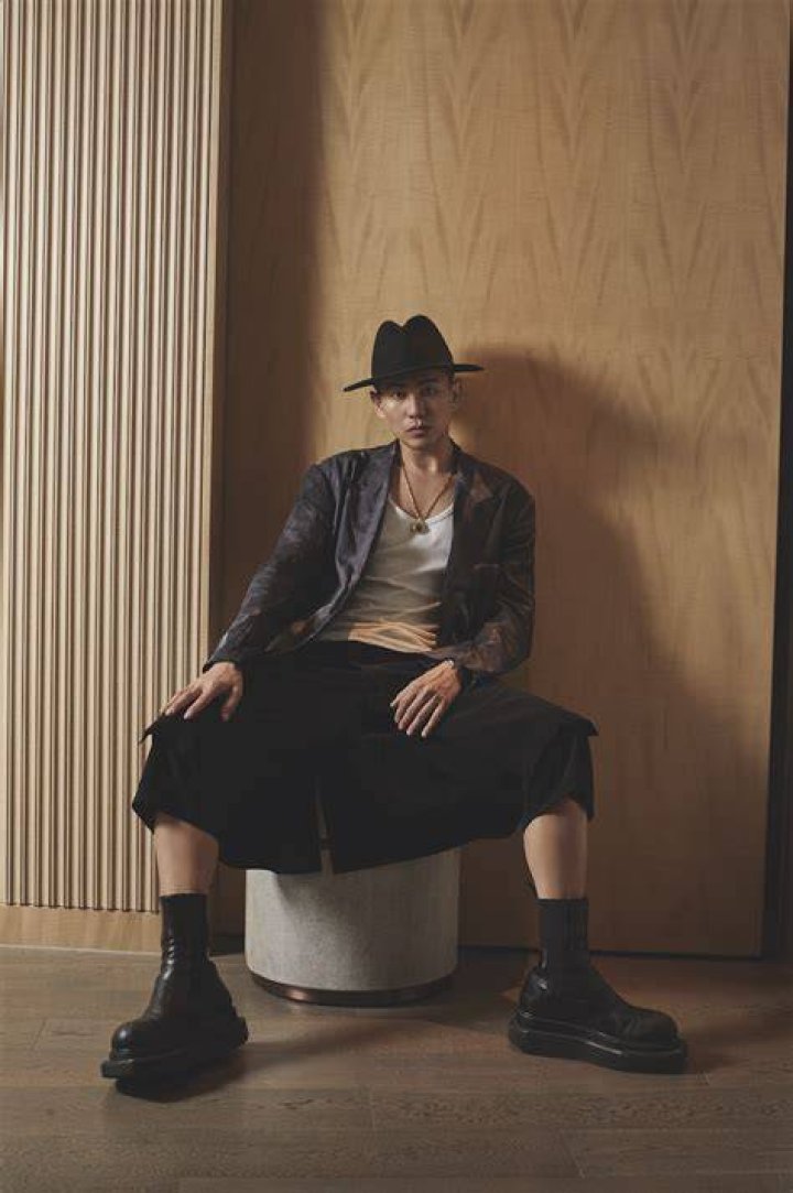 designer han chong of self portrait wears a black motorcycle jacket, a white tee, black pants, and black boots with a platform
