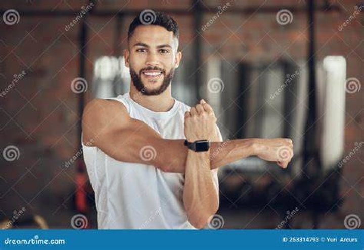 fit young man doing arm exercises with dumbbells
