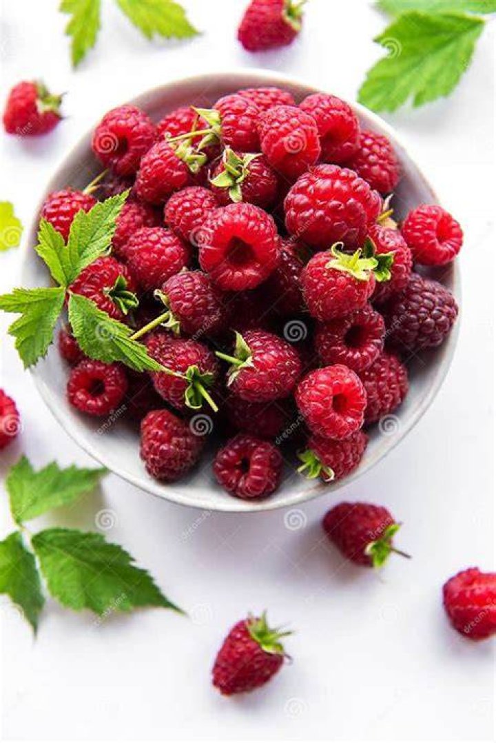 fresh organic ripe raspberry with leaves on wooden table, selective focus