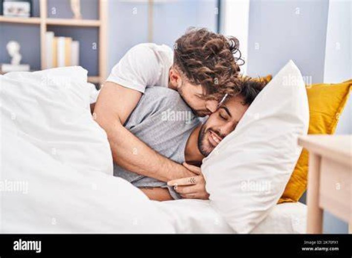 gay couple kissing in bed