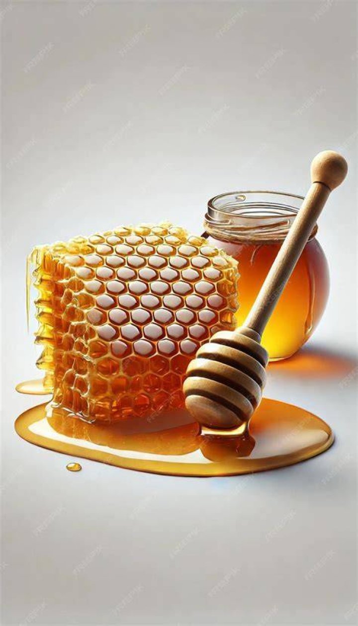 honey dipper and honeycomb on table