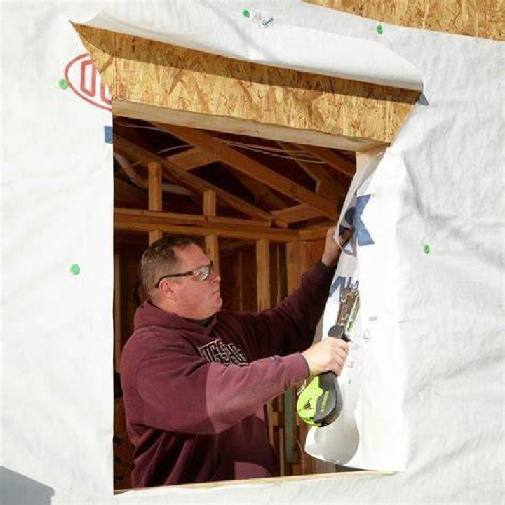 Installing house wraps around open window holes | Construction Pro Tips