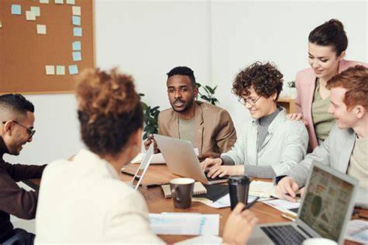 interns and employees working on computers in a office setting