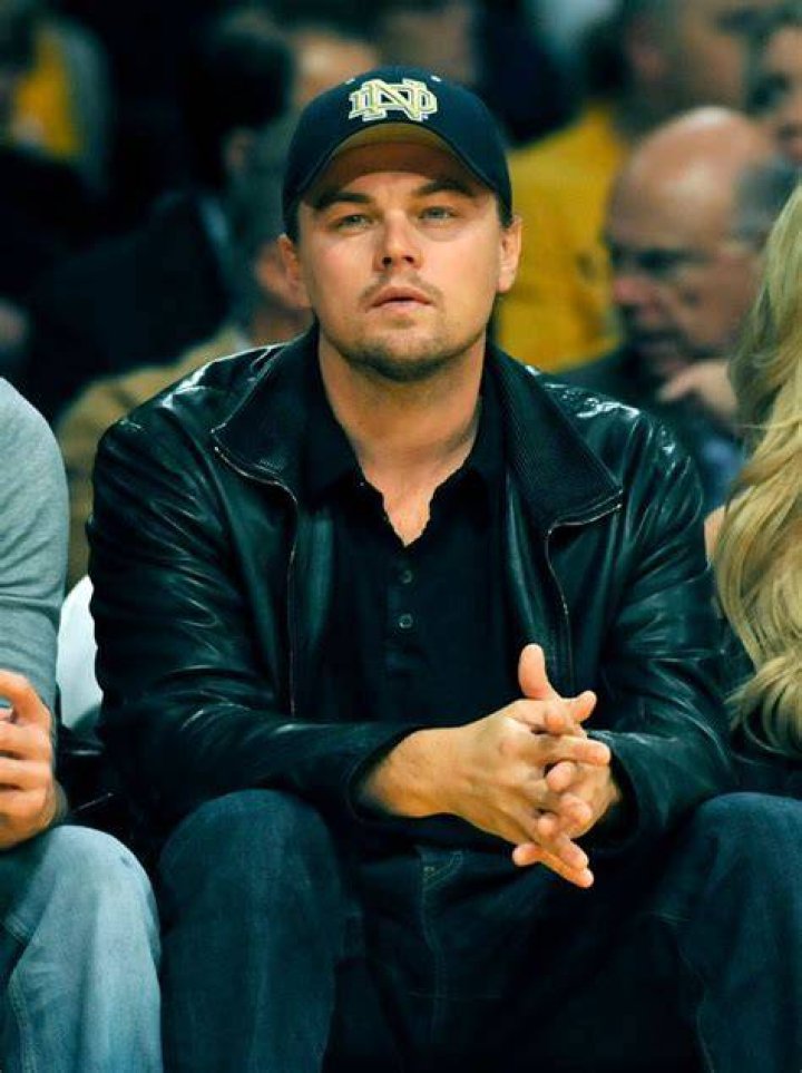 Leonardo DiCaprio (2nd-L) sits courtside with his girlfriend, Israeli model Bar Refaeli (3rd-L) and his stepbrother Adam Farrar (L). Photo / Getty 
