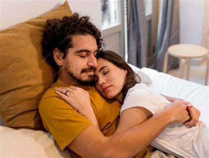 man and woman cuddling on bed