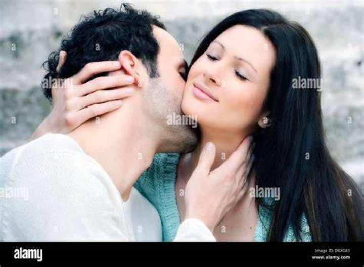 man kissing neck of woman in bed