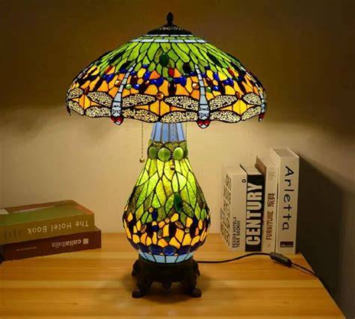 Mother holding lamp shade while arranging furniture outside van while relocating to new house