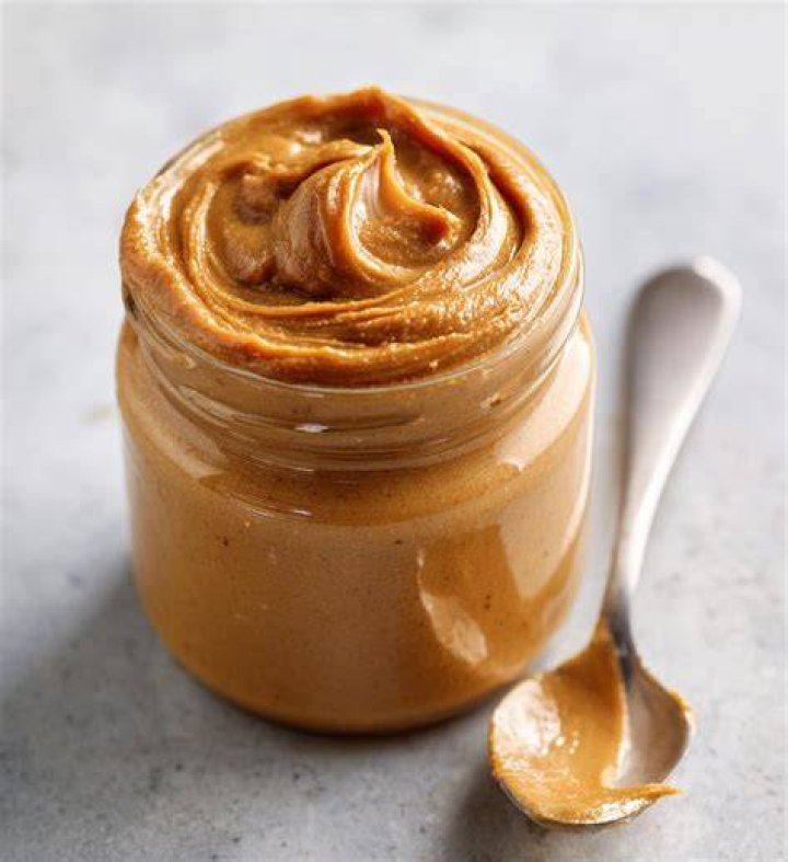 peanut butter jar with scoop of peanut butter