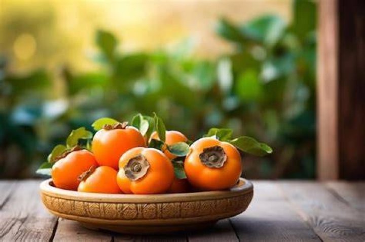 persimmon fruit on old wooden background, top view