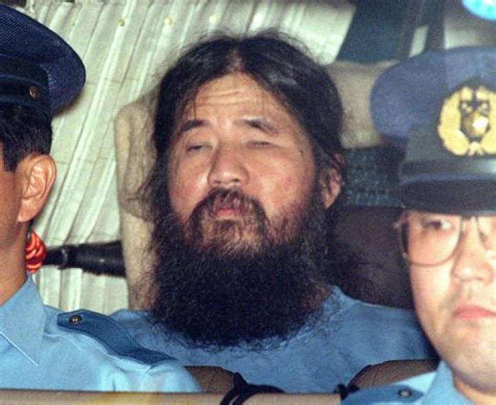 Shoko Asahara, center, sits in a police van following an interrogation in Tokyo.