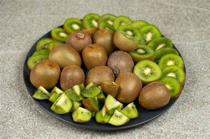sliced fresh kiwi fruit on wood table