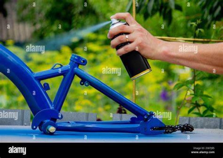 spray painting a bike blue outside