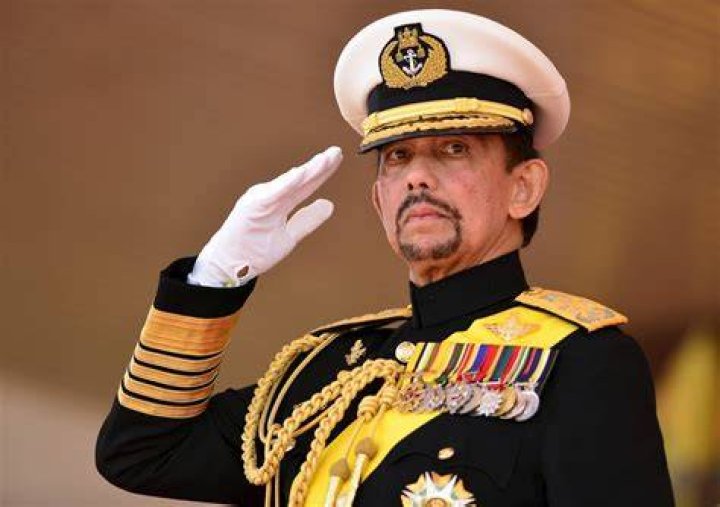 The Sultan of Brunei Hassanal Bolkiah offers a prayer in 2000 with two of his wives at a royal birthday investiture in Nurul Iman Palace. Photo / AP