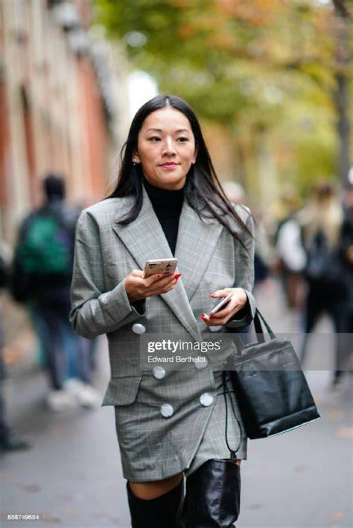 tina leung wears a black blazer dress with sheer stockings and heels at a lunar new year party in 2023