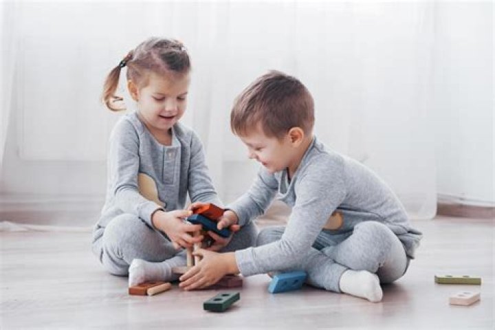 Two kids playing on a lawn