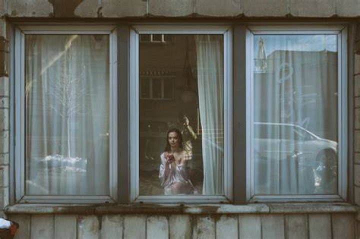 Man looking though blinds. voyeur