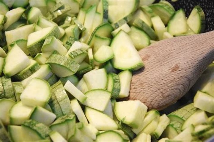 wooden spoon on sliced zucchinis